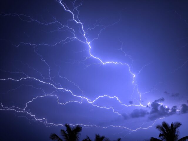 Large flashes of lightning against a purplish night sky.