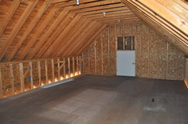 Unfinished bonus room above garage, beams and rafters exposed, uninsulated.