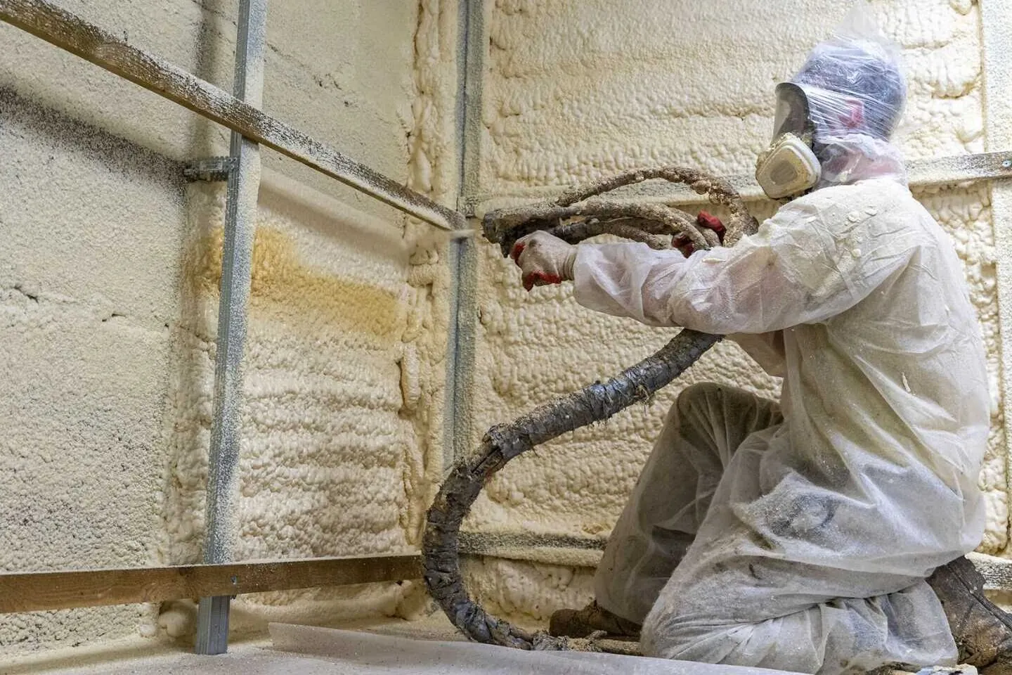 Worker installing spray foam insulation