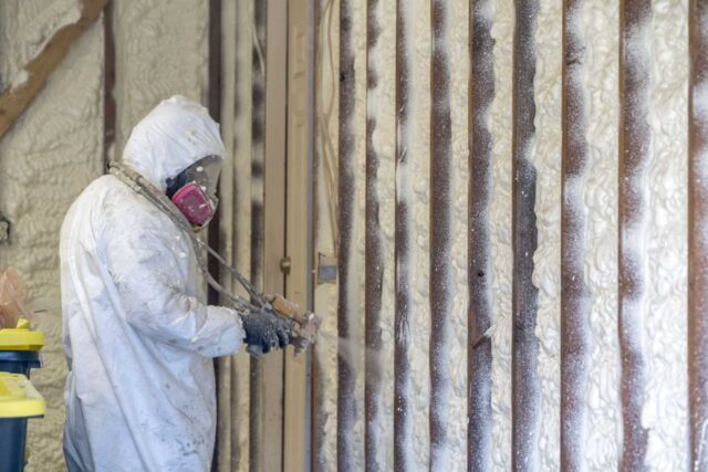 Technician installing spray foam insulation.