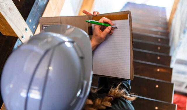 Contractor making notes in notebook